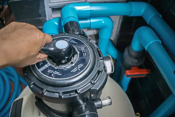 Professional inspection of pool heater and controls during equipment repair service.